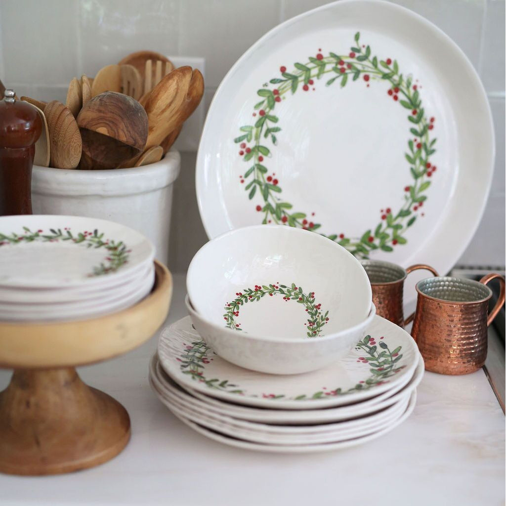 Set of holiday melamine dinnerware in white with a circular holiday pattern
