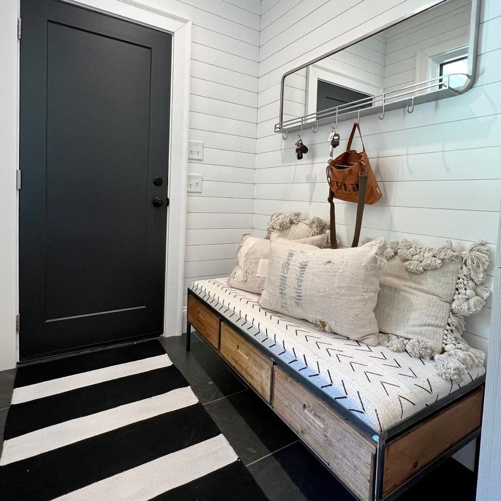 Stylish black & white home entryway with mirror and bench