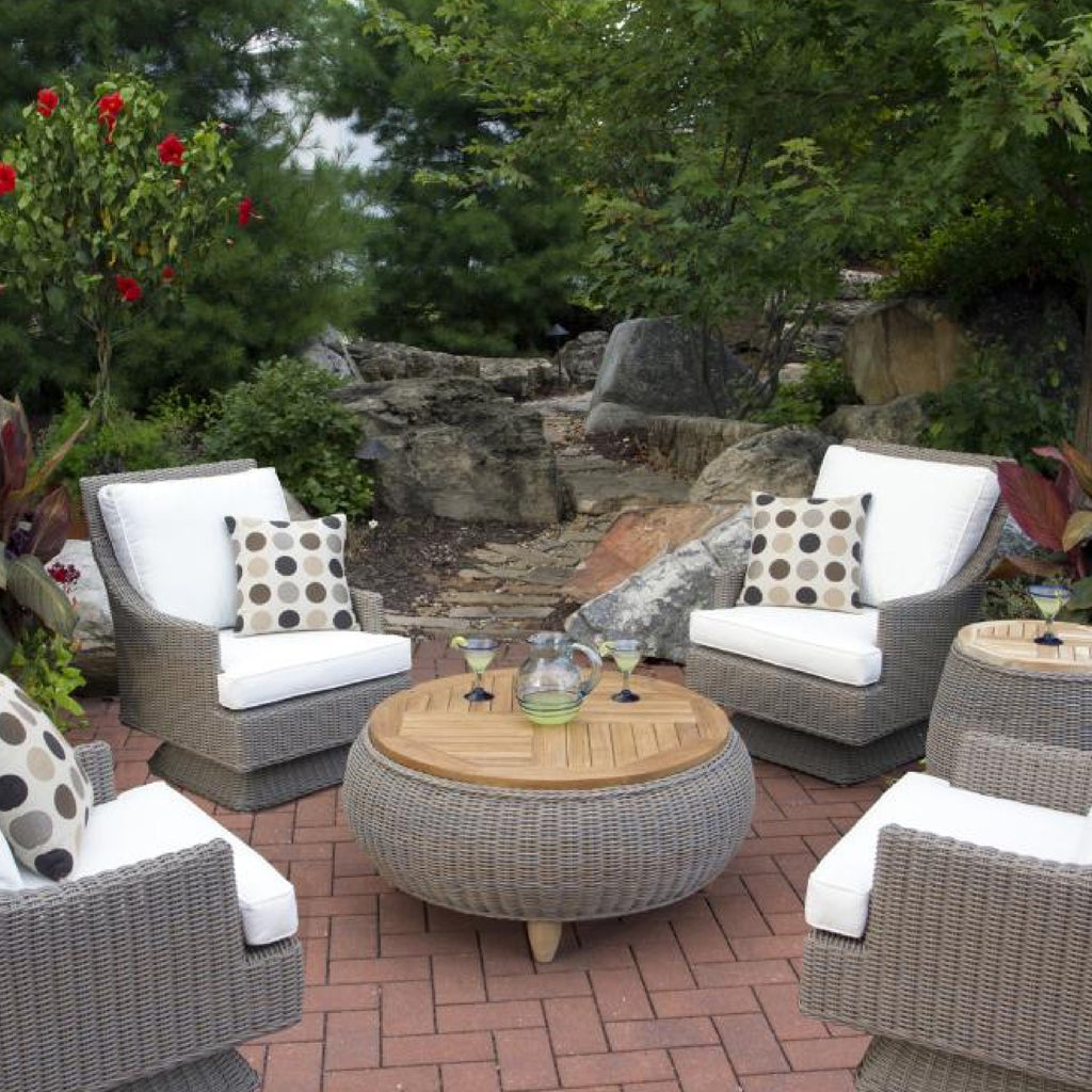 outdoor seating area coffee table grey woven chairs white cushions