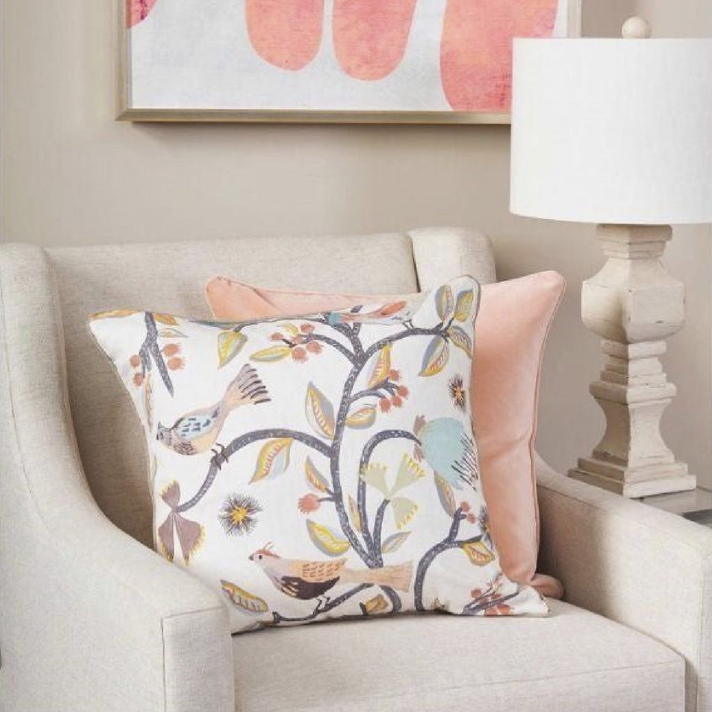 muted floral bird accent pillow and cream chair 