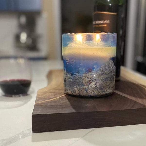 round candle 2 wick textured blue finish handblown glass near wine glass