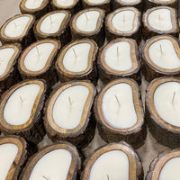 Irregular Tree Bark Candles - Small, from Himalayan Trading Post, with white wax and a single wick, are neatly arranged in rows on a flat surface.