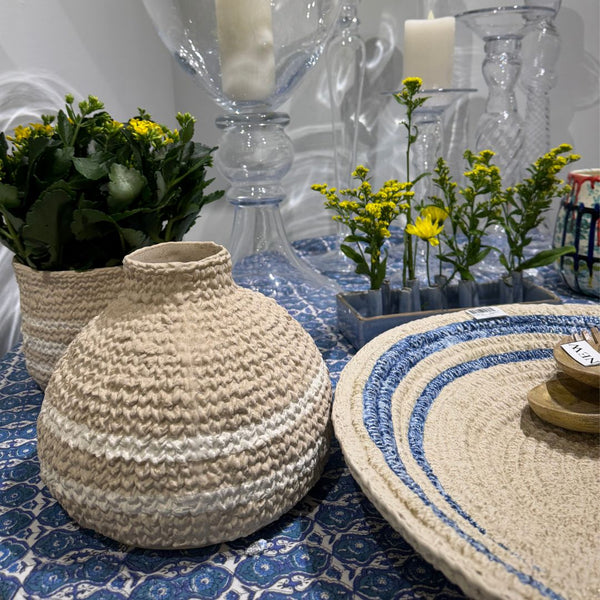 Ceramic Aster Basket Plate by Abigails with tray, woven vase, candles, and yellow flowers on a blue tablecloth.
