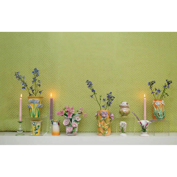 Handmade Mango with Lavender Flower Vase by Abigails and lit candles on a shelf against a textured green wall.