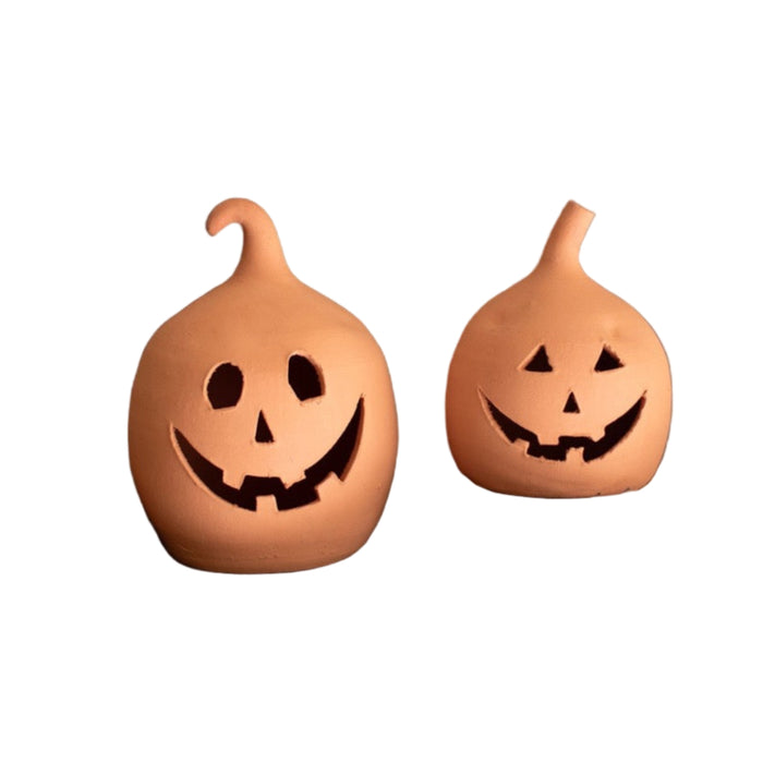 Kalalou's Terracotta Jack-O-Lanterns (set of 2) with smiling faces sit on a dark surface against a black background.