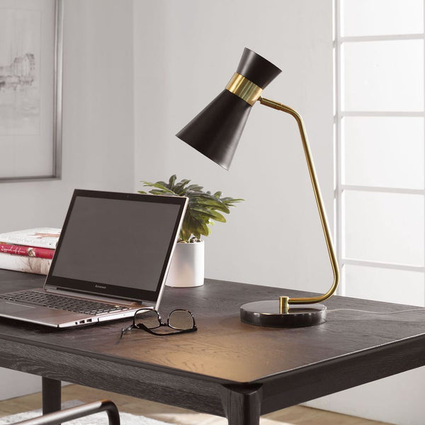 The Uttermost Black + Gold Desk Lamp with a black marble base sits on a modern dark wood desk beside a laptop.