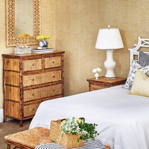 a bedroom with a bamboo headboard and bamboo bench at the end of the bed 