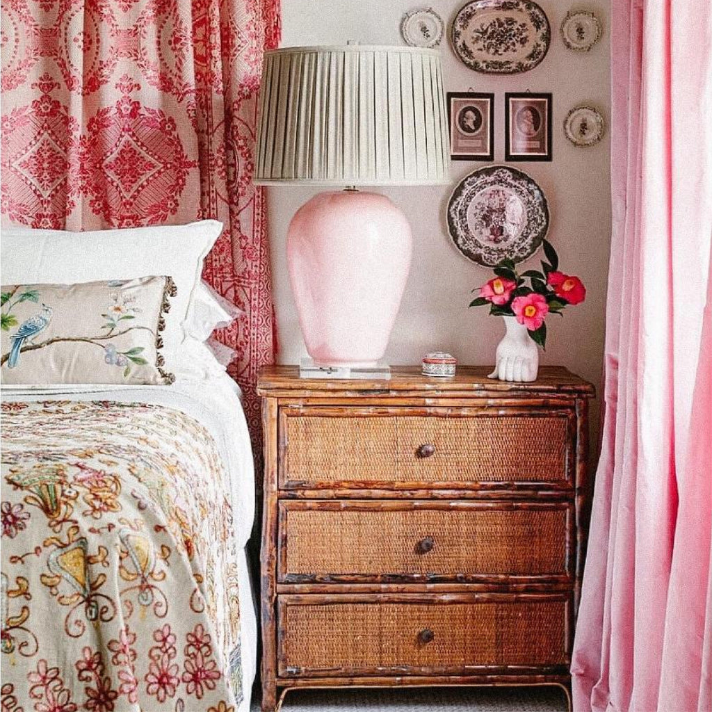 a bedroom with a bamboo headboard and bamboo bench at the end of the bed 