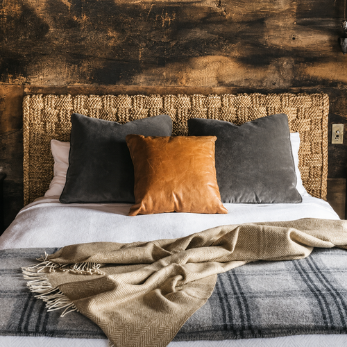 Throw spread across a bed with a natural headboard