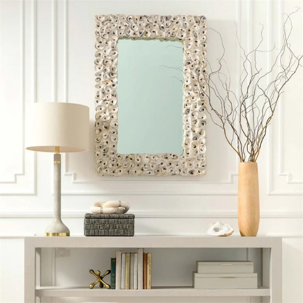 retangular shell framed mirror hanging above neutral console table