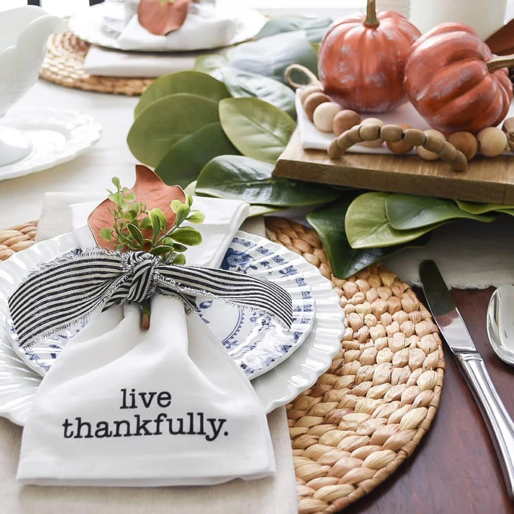 Fall place setting at table with napkin which says live thankfully