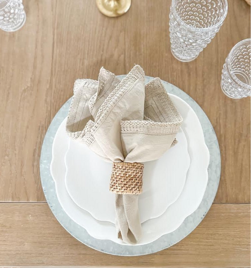 white melamine scalloped plates with linen napkin on a table