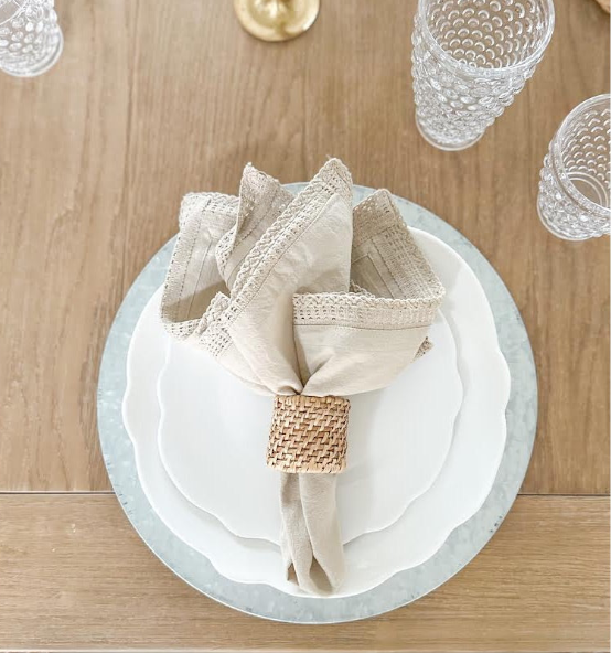 white melamine scalloped plates with linen napkin on a table