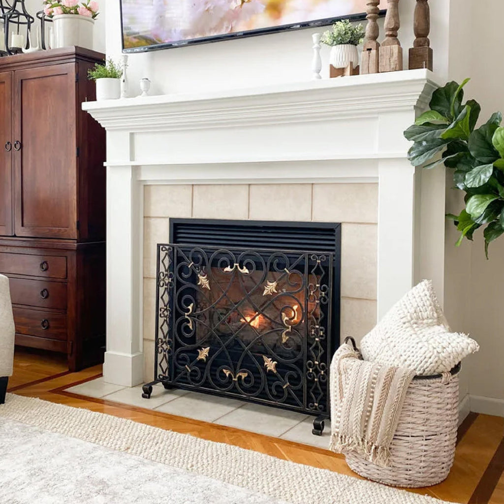 cozy fireplace scene with a metal screen, basket and cozy pillow and throw blank