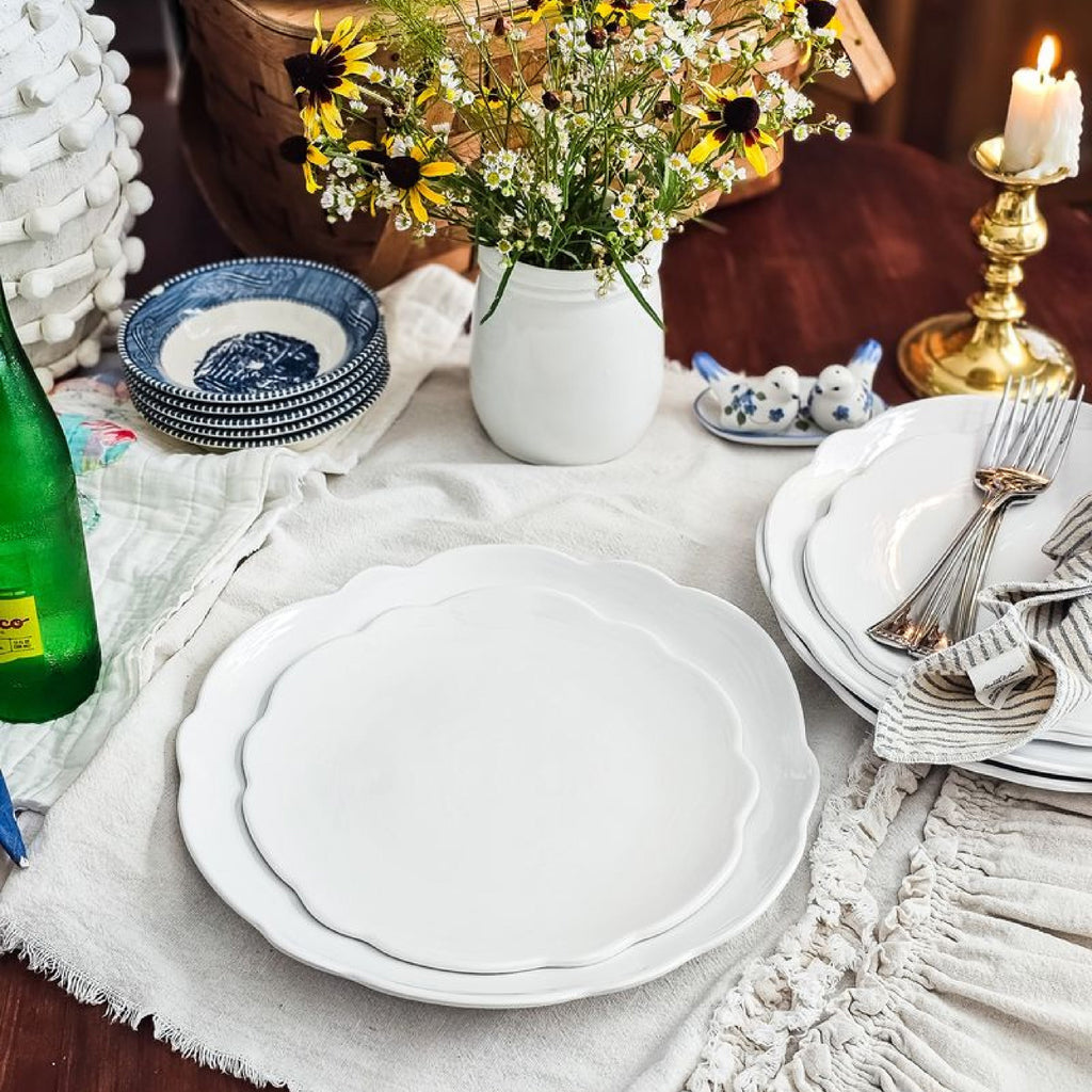 white scalloped plate setting and blue bowls 