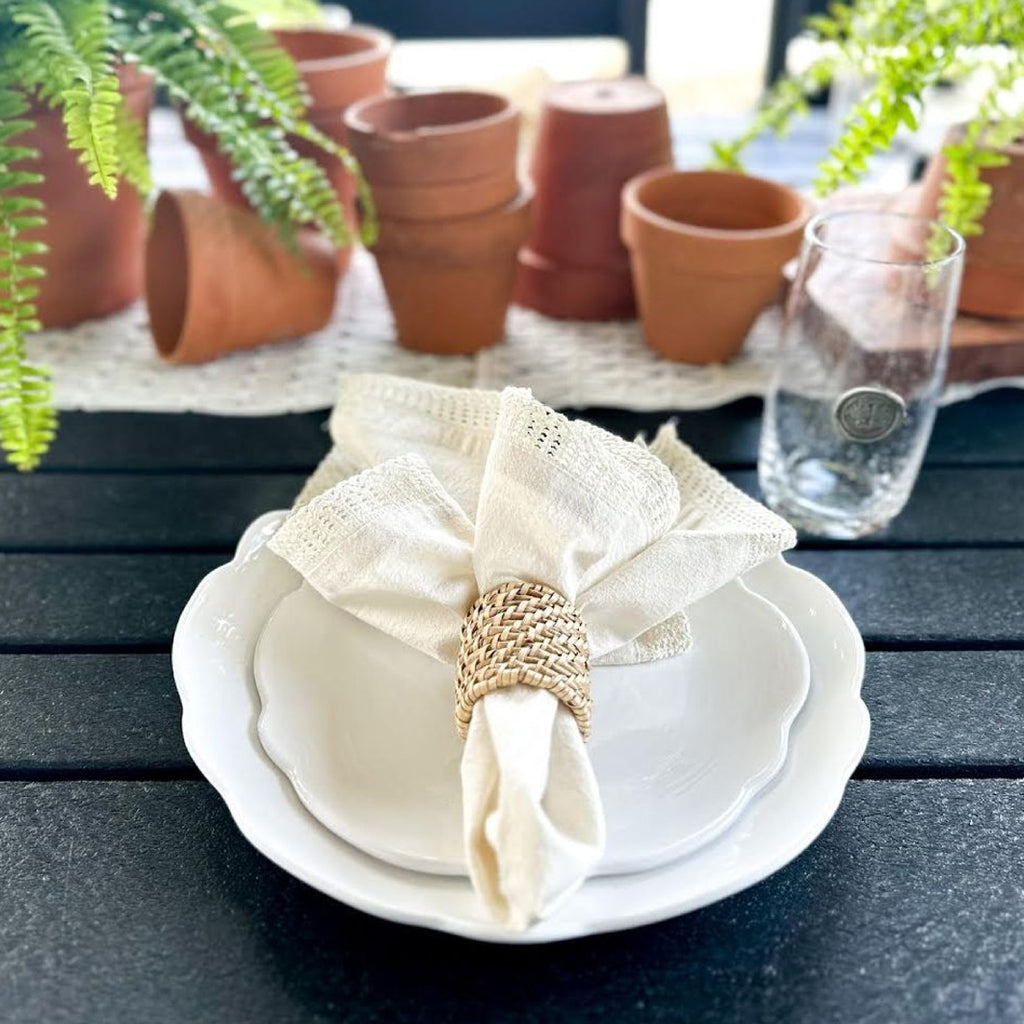 white melamine scalloped dishes on table with cream napkin