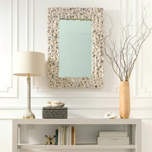 oyster shell mirror over white console table lamp