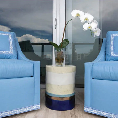 white rattan outdoor seat with blue cushions 
