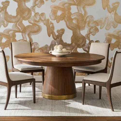 A round wooden dining table with four upholstered chairs, featuring a central bowl of decorative spheres.