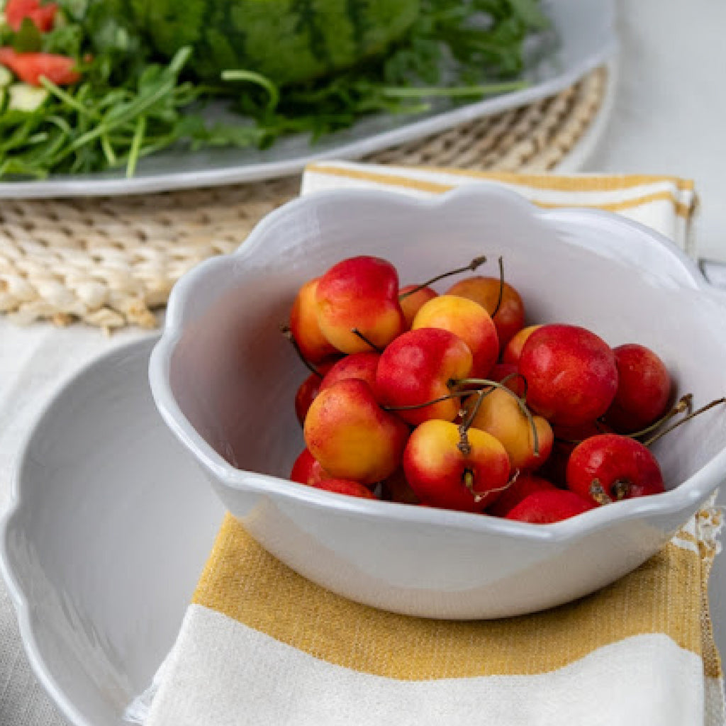 white scalloped bowl of cherries