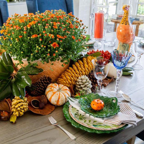 Table set for a Fall meal with a set of green and leaf pattern dishes