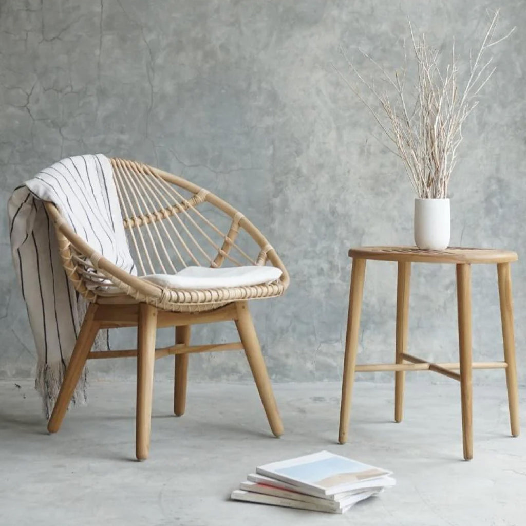 woven chair and side table with striped throw blanket