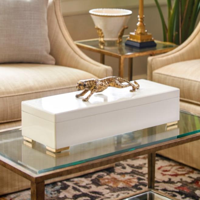 Gold feather sconce with white shade on a light green wall with additional furnishings - by Chelsea House