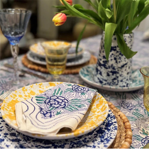 speckled yellow dishes and cactus glass on table setting