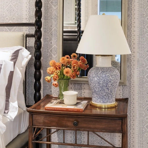 bedside table with blue white lamp and decor  