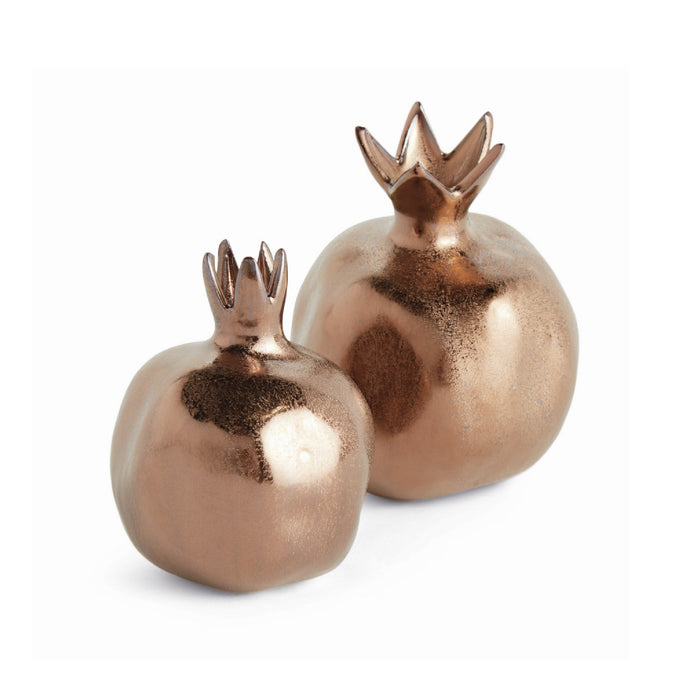 Two bronze-colored decorative pomegranates with crown-like tops on a white background