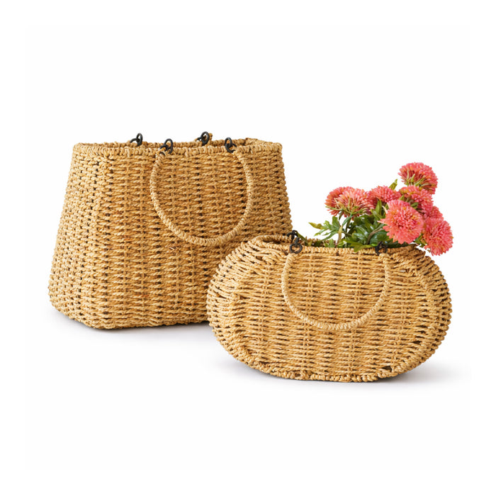 Two woven baskets with handles, one containing pink flowers, on a white background