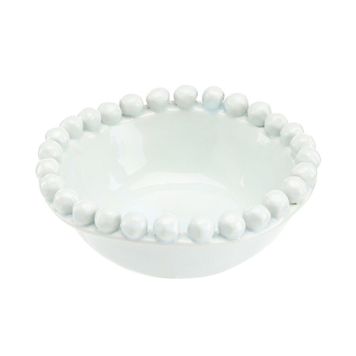White ceramic bowl with bead-like embellishments on a white background