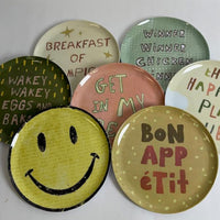 Set of colorful plates with various sayings on a white background