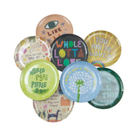 Collection of colorful buttons with various phrases and designs on a white background