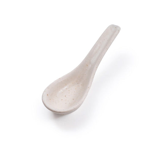 A small ceramic spoon in a speckled off-white glaze, photographed on a clean white background.