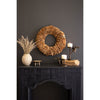 Dark mantle featuring a stunning Mushroom Sponge Wreath centerpiece by Kalalou, a beige vase crafted from natural materials filled with dried grass, elegant candle holders adorned with candles, and books on display.