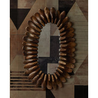 An oval wall mirror with a decorative frame made of many curved wooden pieces arranged in a sunburst pattern, mounted on a geometric patterned wall.