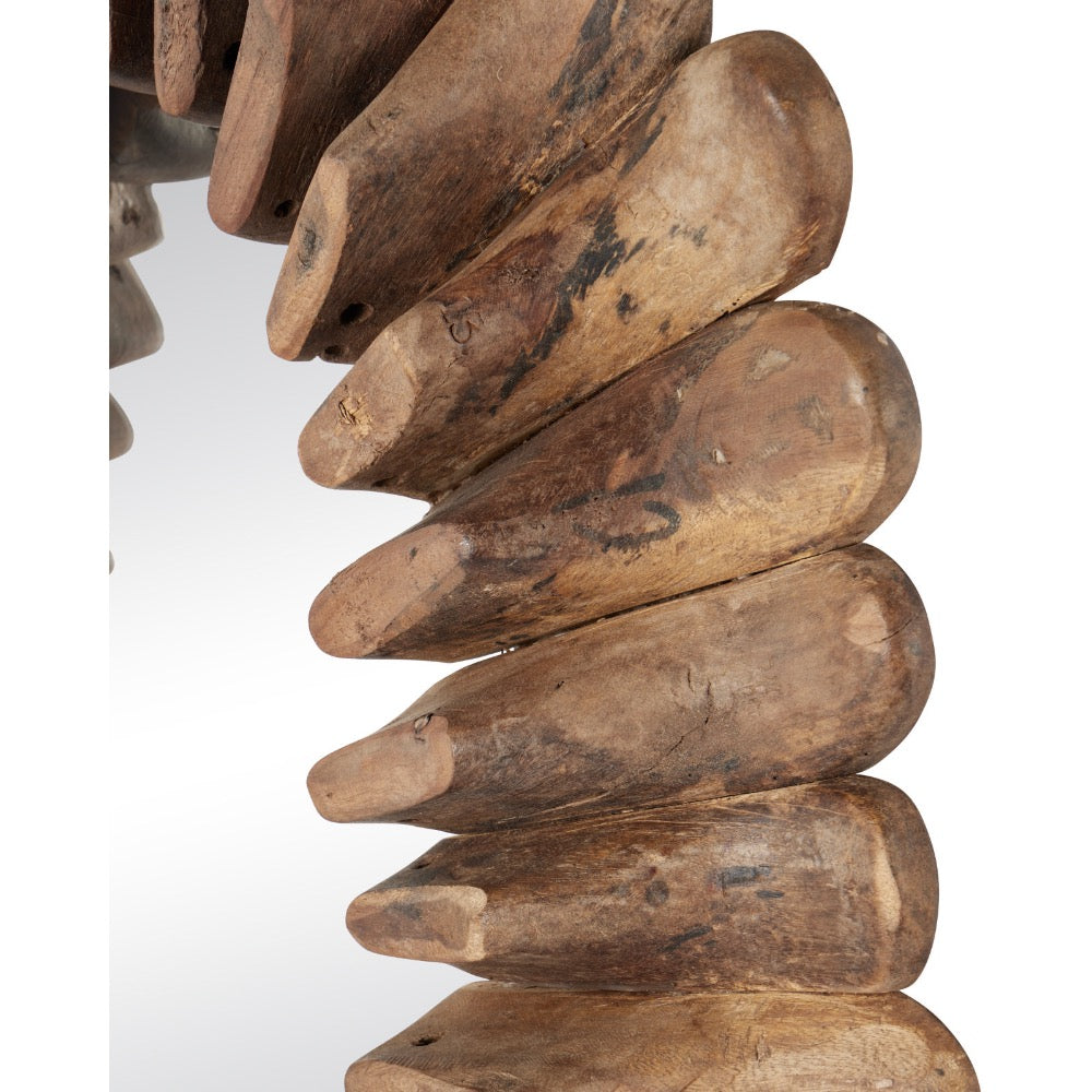 A close-up of a decorative wall mirror with a curved, tiered frame made of stacked natural wood blocks showing a weathered brown wood grain pattern, set against a plain white background.