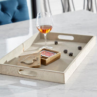 Beige tray with a glass of wine, cards, and snacks on a marble surface.
