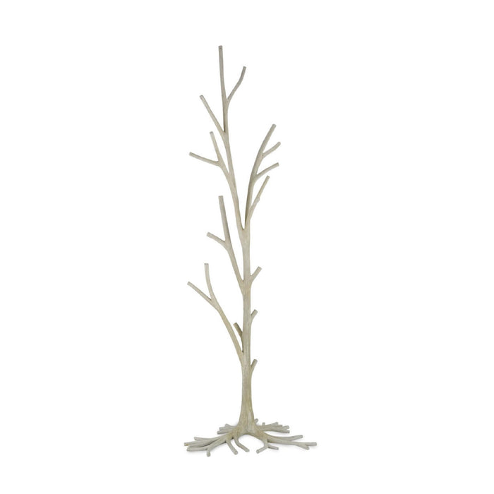 A decorative floor-length coat rack designed to look like a bare tree trunk with branching limbs and exposed roots, finished in a light warm gray or off-white tone, shown against a plain white background.