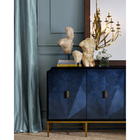 Decorative blue cabinet with geometric design, gold accents, and classical sculptures in a room.