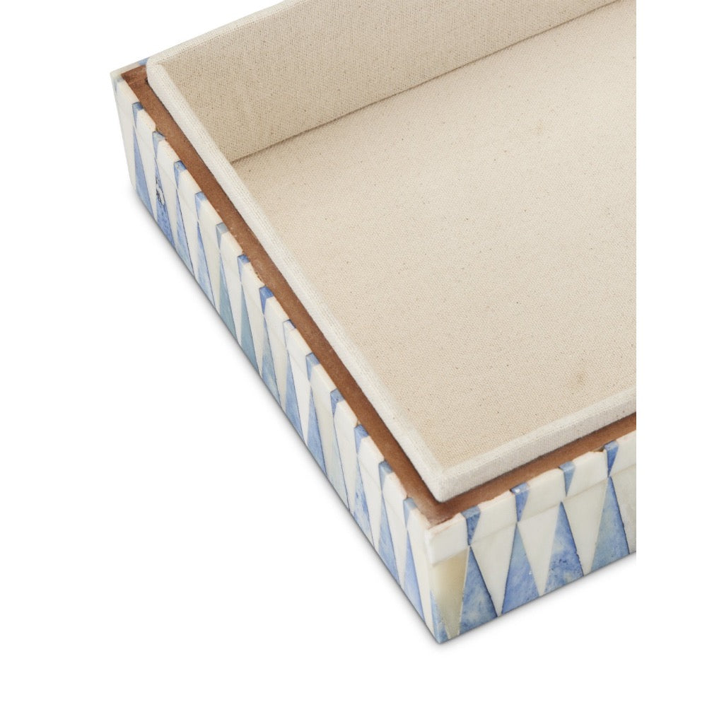 Decorative box with blue and white pattern on a beige cushion