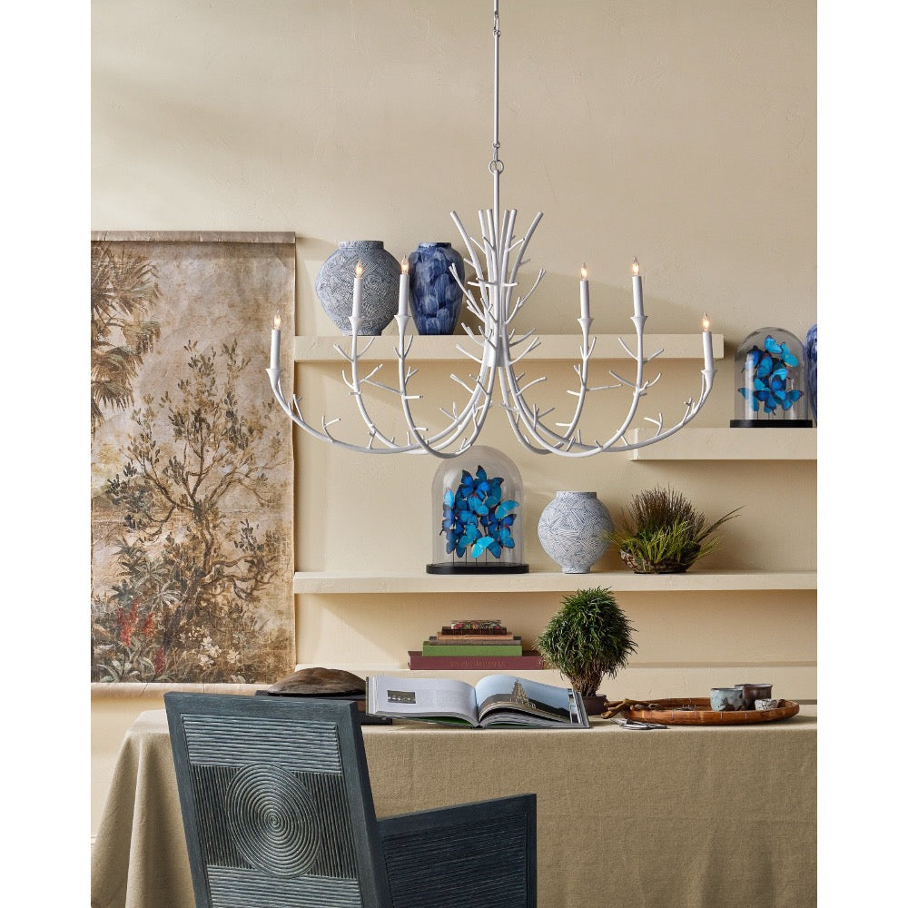 Dining room with a chandelier, table, chairs, and decorative items on shelves.