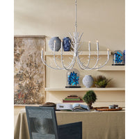 Dining room with a chandelier, table, chairs, and decorative items on shelves.