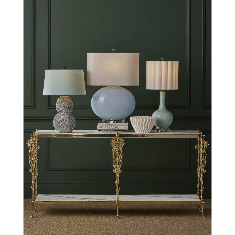 Decorative console table with lamps against a dark green wall