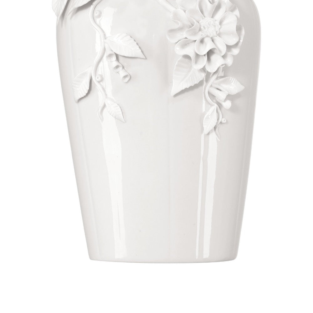 White ceramic vase with floral designs on a white background
