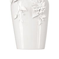 White ceramic vase with floral designs on a white background