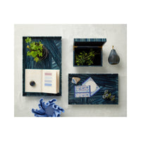 Set of decorative boxes with plants and stationery items on a textured surface