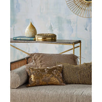 A styled interior scene showing a beige upholstered sofa with decorative throw pillows, a gold-framed console table, and a textured blue wall. The product appears to be the sofa/pillow set in a real room setting, so this fits Lifestyle rather than Product/Packaging.