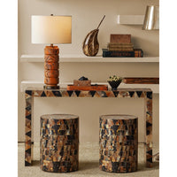 Decorative console table with patterned legs and stools in a room setting.